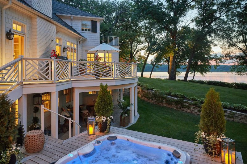 Luxurious mansion near a lake with Jacuzzi and green lawn