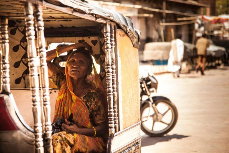 Old lady in the rickshaw bike covering from sun. Rajasthan, India