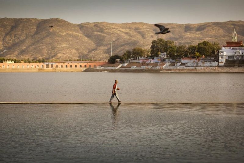 Lake Pichola in Udaipur. Man walking on the small emerged wall